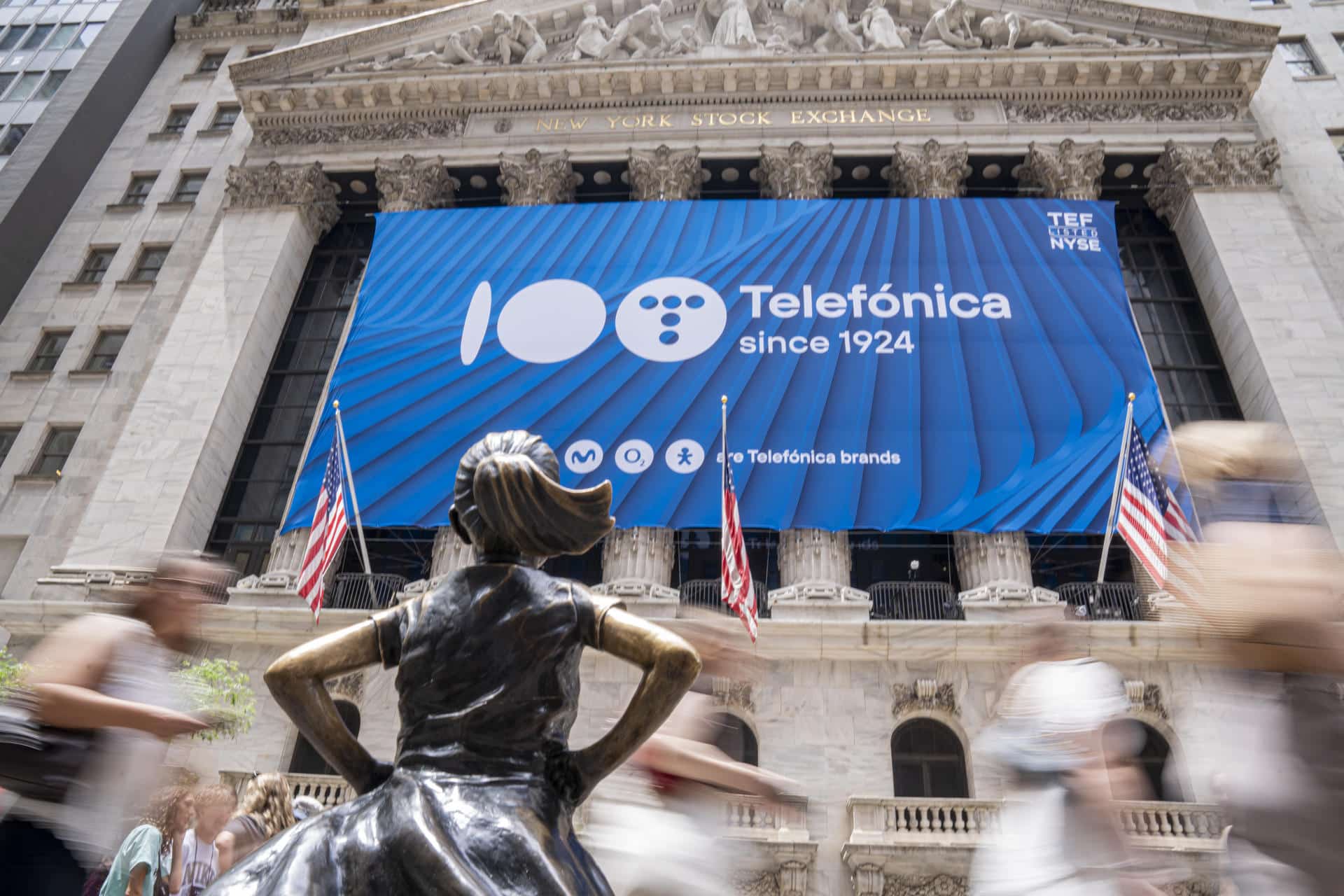 Imagen de archivo de la icónica estatua de "La niña sin miedo" de Wall Street ante una lona que celebraba los 100 años de Telefónica en la fachada de la bolsa de valores de Nueva York (NYSE) en Wall Street, Nueva York (EE. UU). . EFE/Ángel Colmenares