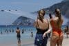 Personas observan la exhibición aérea de la patrulla de helicópteros ASPA del Ejército del Aire y del Espacio de España sobre la playa de Ipanema en Río de Janeiro (Brasil). EFE/ André Coelho
