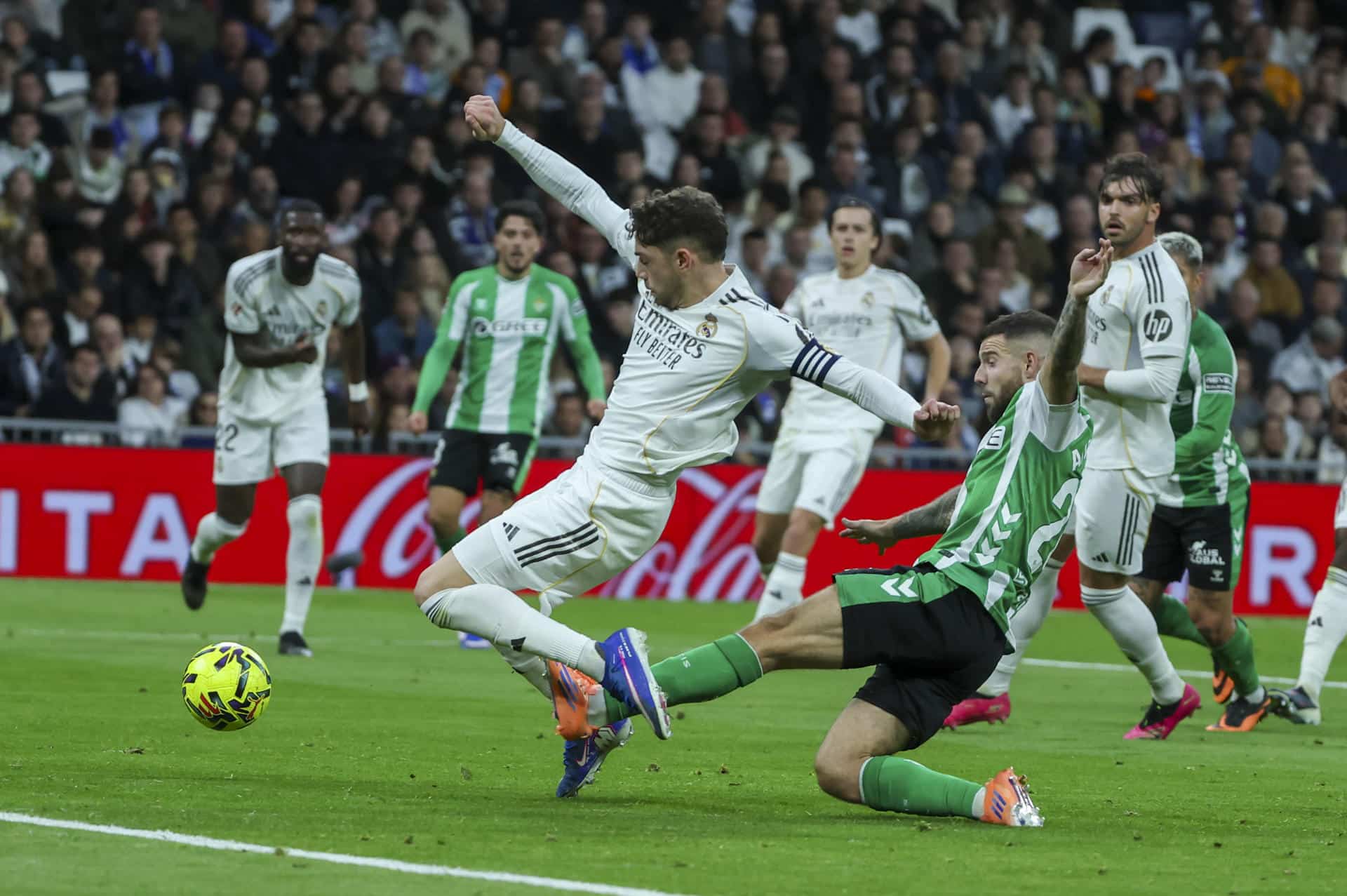 El centrocampista uruguayo del Real Madrid Fede Valverde (i) cae ante el centrocampista del Betis Aitor Ruibal durante el partido de LaLiga entre el Real Madrid y el Betis, este domingo en el estadio Santiago Bernabéu. EFE/ Kiko Huesca