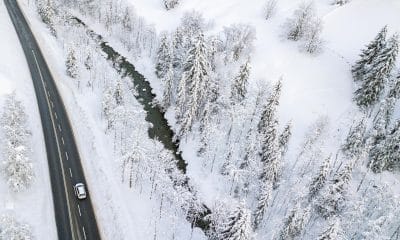 Un coche conduce por una carretera que discurre entre un bosque cubierto de nieve, cerca de Filzmoos (Austria), en una imagen de archivo. EFE/ Christian Bruna