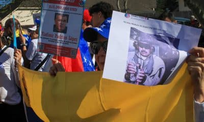 Fotografía de archivo de una ciudadana venezolana mientras sostiene carteles con la imagen del ministro de Defensa de Venezuela, Vladimir Padrino López, y del presidente de Venezuela, Nicolás Maduro, durante una manifestación en apoyo al presidente de Estados Unidos, Donald Trump, en Houston, Texas (Estados Unidos). EFE/ Carlos Ramírez