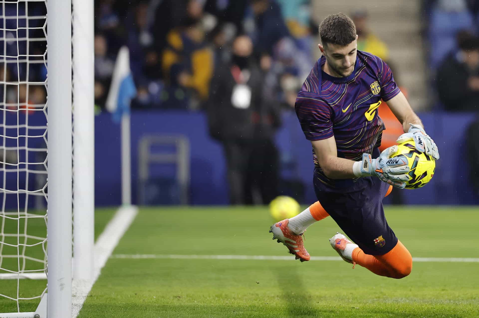 El guardameta del Barcelona Joan García calienta antes del partido de la jornada 18 de LaLiga entre el RCD Espanyol y el FC Barcelona, este sábado en el RCDE Stadium. EFE/Andreu Dalmau