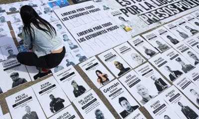 Una persona organiza carteles con imágenes de presos políticos este martes, en la Plaza del Rectorado UCV, en Caracas (Venezuela). EFE/ Miguel Gutiérrez