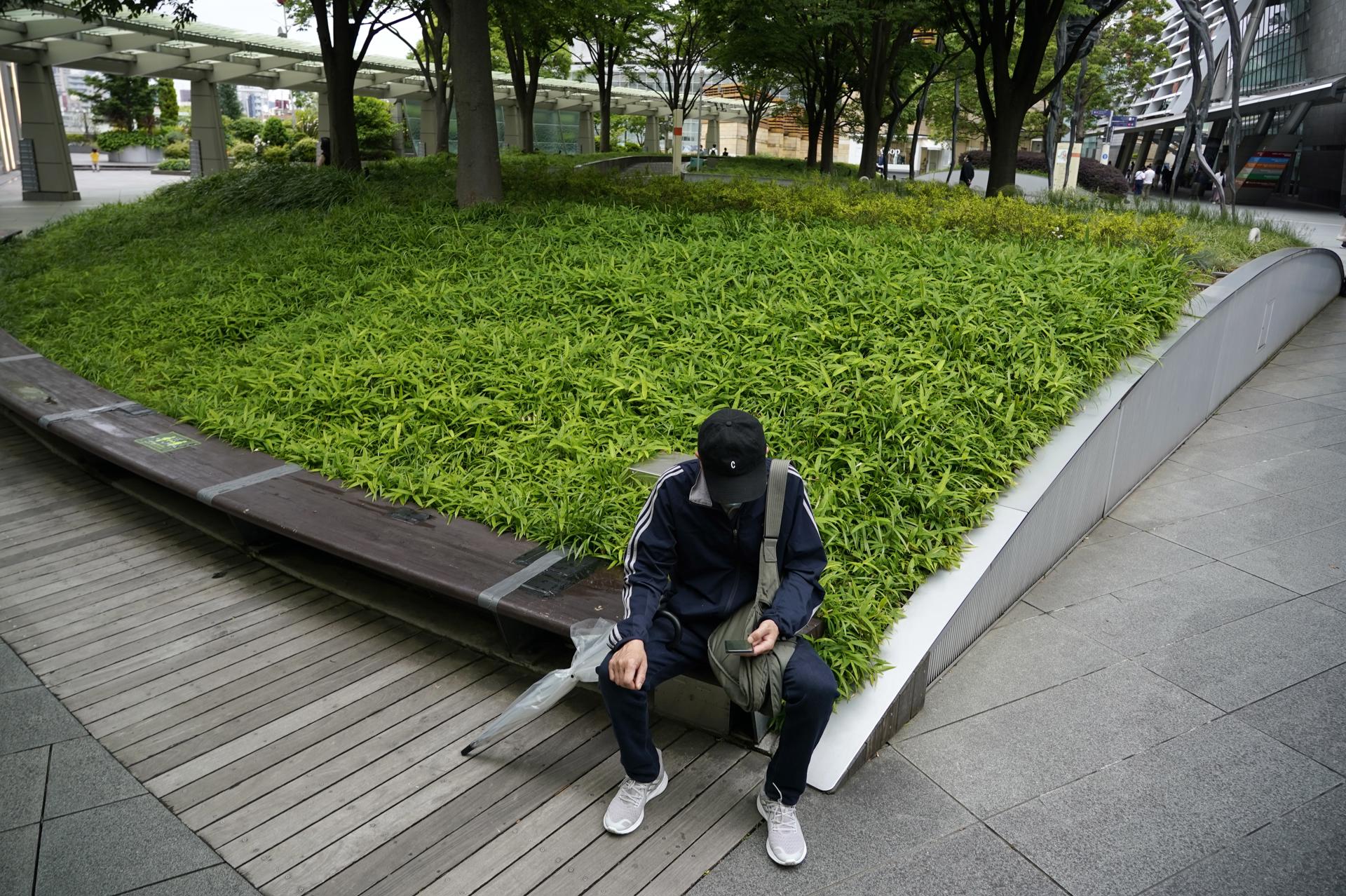 Fotografía de archivo, tomada el 31/05/2022, que muestra a un hombre mirando su teléfono móvil en Tokio, Japón. EFE/EPA/FRANCK ROBICHON
