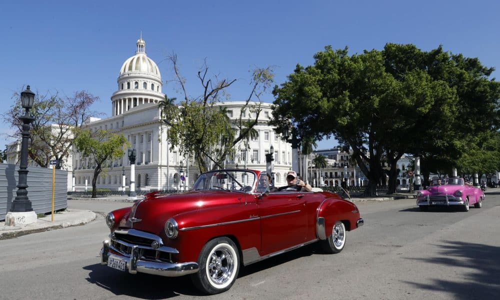 Turistas pasean en un auto clásico cerca del Capitolio de La Habana en La Habana (Cuba). EFE/ Ernesto Mastrascusa