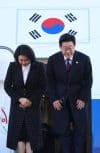 El presidente surcoreano, Lee Jae Myung (d), junto a su esposa, Kim Hea Kyung, saludan en la base aérea de Seúl antes de partir hacia la prefectura de Nara, oeste de Japón, para mantener conversaciones de cumbre con la primera ministra japonesa Sanae Takaichi, en Seongnam, Corea del Sur. EFE/YONHAP