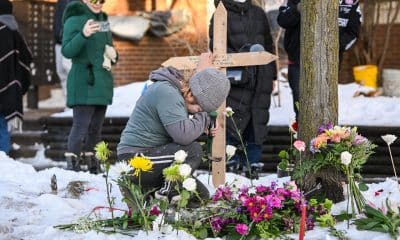 Una mujer ora en un monumento improvisado en el lugar en el que una mujer fue asesinada a tiros por un agente de Inmigración y Control de Aduanas (ICE) en Minneapolis, Minnesota. EFE/EPA/CRAIG LASSIG