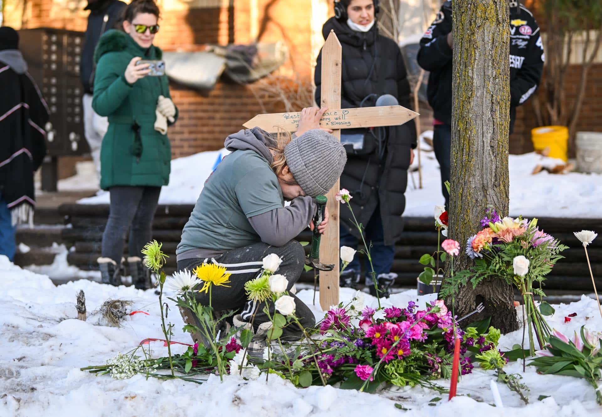 Una mujer ora en un monumento improvisado en el lugar en el que una mujer fue asesinada a tiros por un agente de Inmigración y Control de Aduanas (ICE) en Minneapolis, Minnesota. EFE/EPA/CRAIG LASSIG