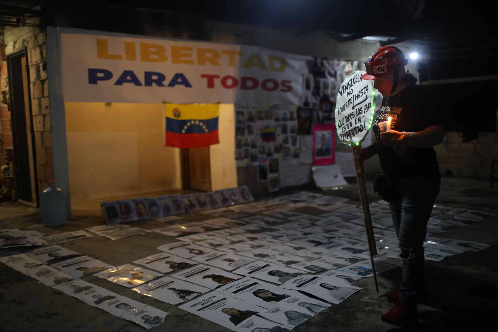 Fotografía del 15 de enero de 2026 de una mujer que observa imágenes de presos políticos durante una vigilia en los alrededores de la cárcel militar Ramo Verde este jueves, en Los Teques, estado de Miranda (Venezuela). EFE/ Miguel Gutiérrez