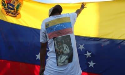 Un hombre sostiene una bandera de Venezuela durante una manifestación en México de celebración por la captura de Nicolás Maduro. EFE/ Alonso Cupul