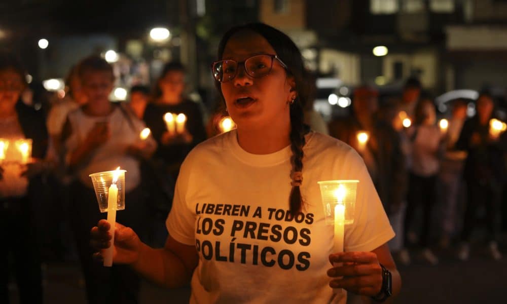 Una mujer sostiene velas durante una vigilia afuera del centro penitenciario Rodeo I este viernes, en el municipio Zamora estado Miranda (Venezuela). EFE/ STR