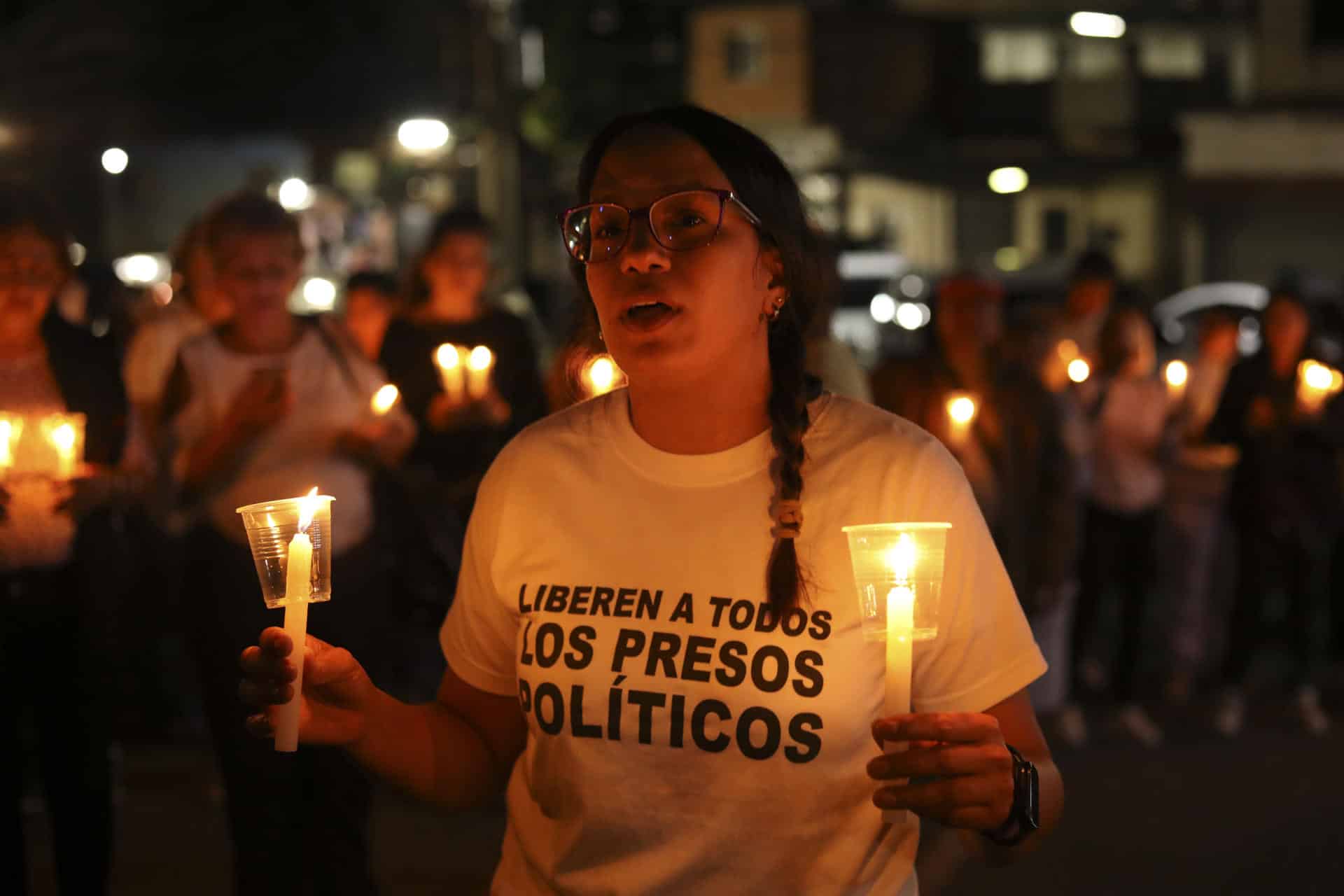 Una mujer sostiene velas durante una vigilia afuera del centro penitenciario Rodeo I este viernes, en el municipio Zamora estado Miranda (Venezuela). EFE/ STR