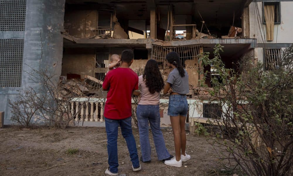 Personas observan un edificio afectado por un explosivo, este 4 de enero de 2026 en Catia La Mar (Venezuela).EFE/ Miguel Gutiérrez