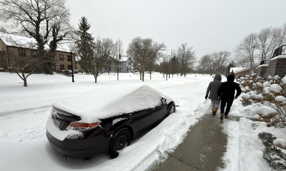Dos personas caminan al lado de una calle afectada por la nieve este domingo en la ciudad de Hudson, Ohio (EE.UU.). EFE/ Rodrigo Sepúlveda