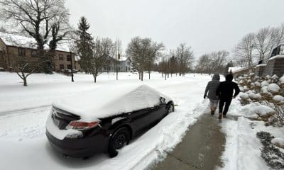 Dos personas caminan al lado de una calle afectada por la nieve este domingo en la ciudad de Hudson, Ohio (EE.UU.). EFE/ Rodrigo Sepúlveda