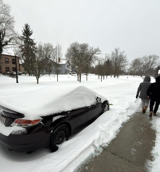 Dos personas caminan al lado de una calle afectada por la nieve este domingo en la ciudad de Hudson, Ohio (EE.UU.). EFE/ Rodrigo Sepúlveda
