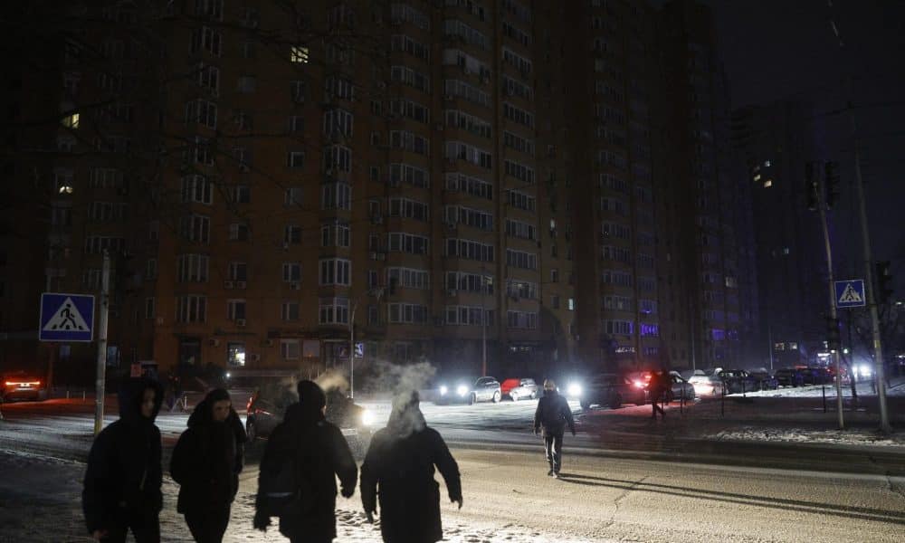 Varias personas caminan con linternas por la calle oscura durante un corte de electricidad en Kiev, Ucrania, en una imagen del 13 de enero de 2026. EFE/EPA/SERGEY DOLZHENKO