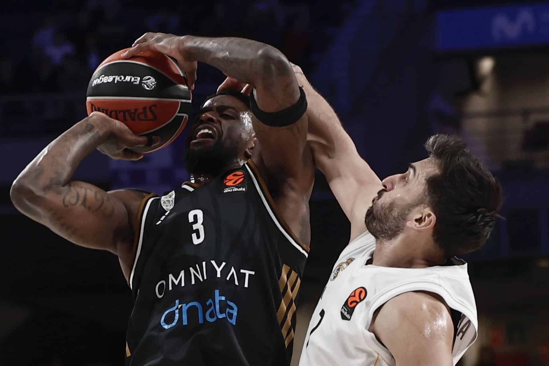 El base argentino del Real Madrid, Facundo Campazzo (d) defiende al alero estadounidense del Dubai Basketball, Dwayne Bacon, durante el partido de la jornada 19 de la EuroLiga que Real Madrid y Dubai Basketball disputan este viernes en el Movistarf Arena, en Madrid. EFE/Sergio Pérez