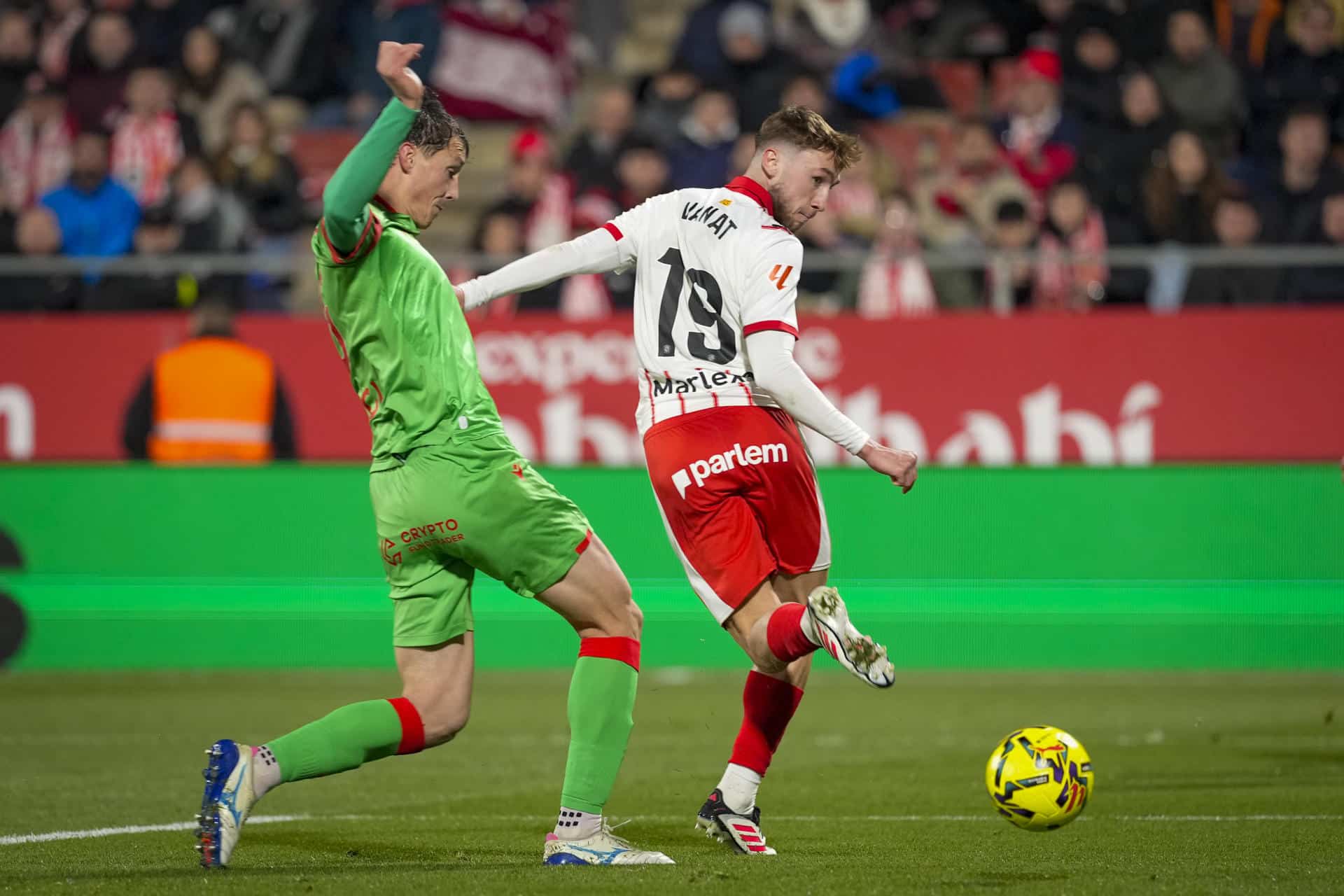 El delantero ucraniano del Girona, Vladyslav Vanat (d), remata ante el defensor de Osasuna en la jugada que ha conseguido el primer gol de su equipo durante el encuentro correspondiente a la jornada 19 de Laliga EA Sports que disputaron Girona y Osasuna en el estadio municipal de Montilivi, en la capital gerundense. EFE/David Borrat.