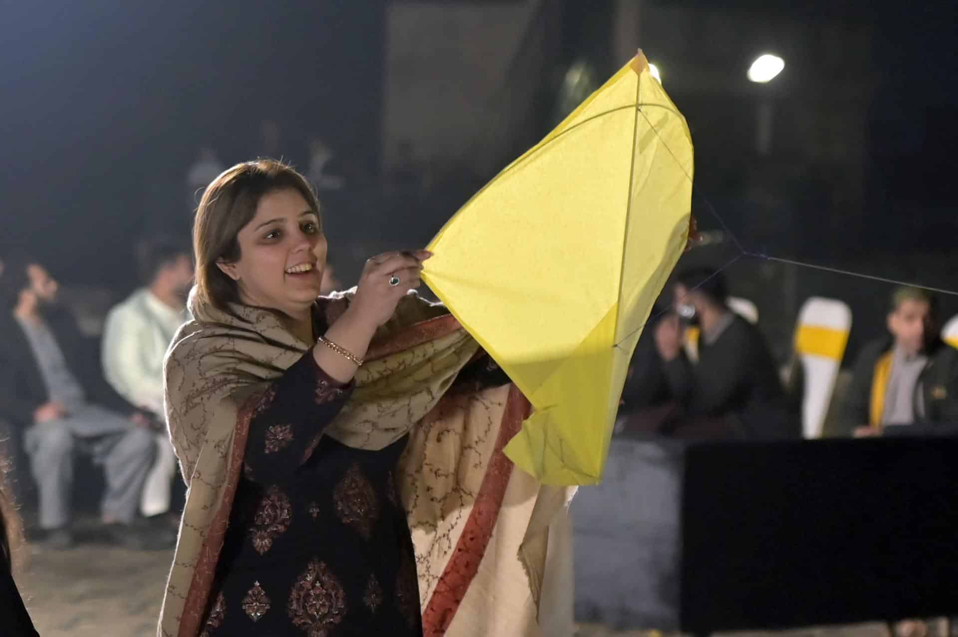 Una mujer vuela una cometa durante el festival Basant de Lahore. EFE/EPA/A. HUSSAIN