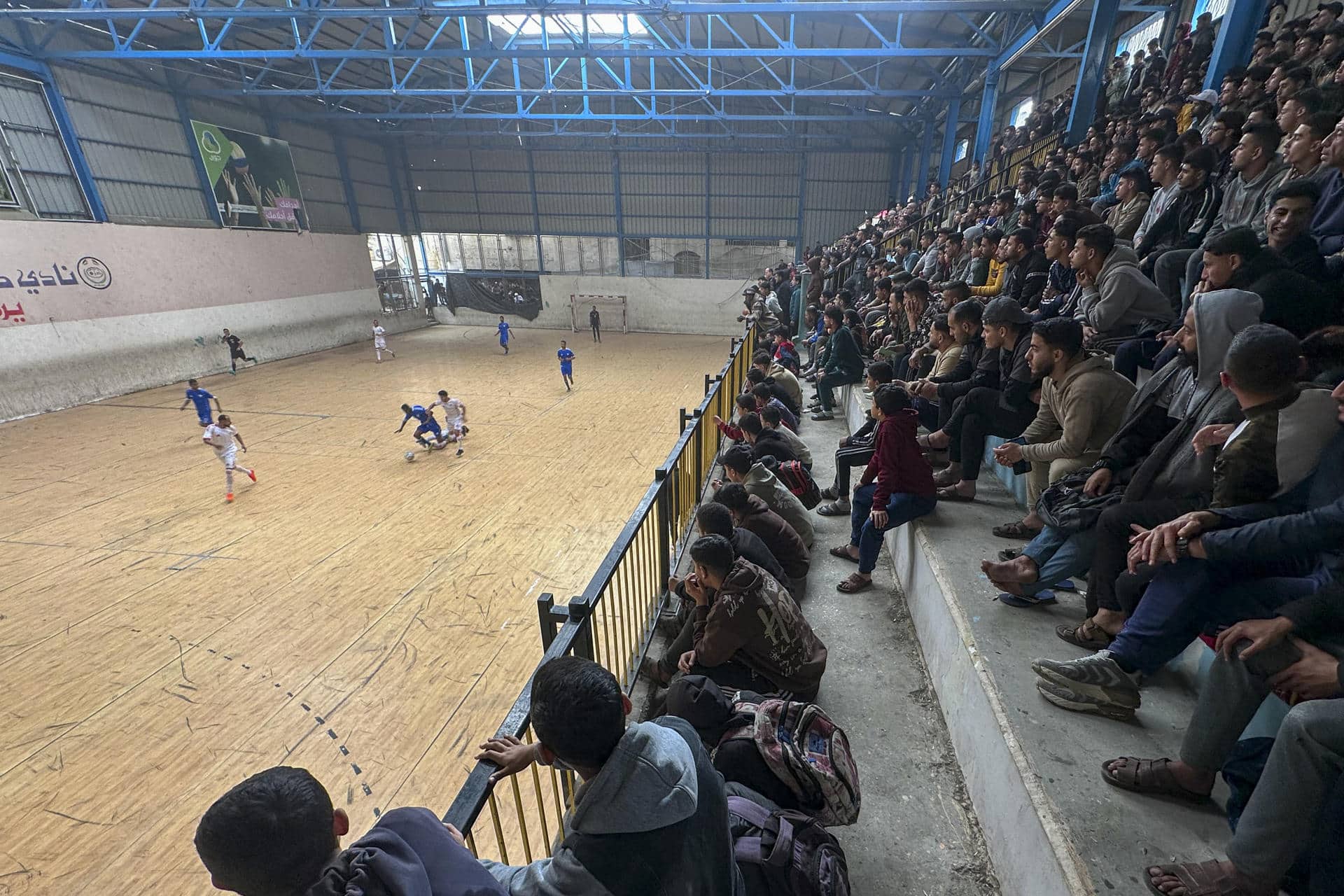 En la ciudad de Nuseirat, en el centro de la Franja de Gaza, tras más de dos años sin campeonatos de fútbol por la ofensiva de Israel, el balón volvió a correr por uno de los pequeños estadios que sobrevivió a los bombardeos israelíes y que ahora acoge los partidos de un nuevo campeonato. Con todos los campos de fútbol 7 y 11 que había en Gaza destruidos ahora por los ataques del Ejército, este campeonato organizado por la Federación Palestina de Fútbol (PFA en inglés) solo se puede desarrollar en pistas de fútbol 5 y pabellones de futsal como el de Al Nusirate que no han resultado dañados por la ofensiva.-EFE/ Ahmad Awad