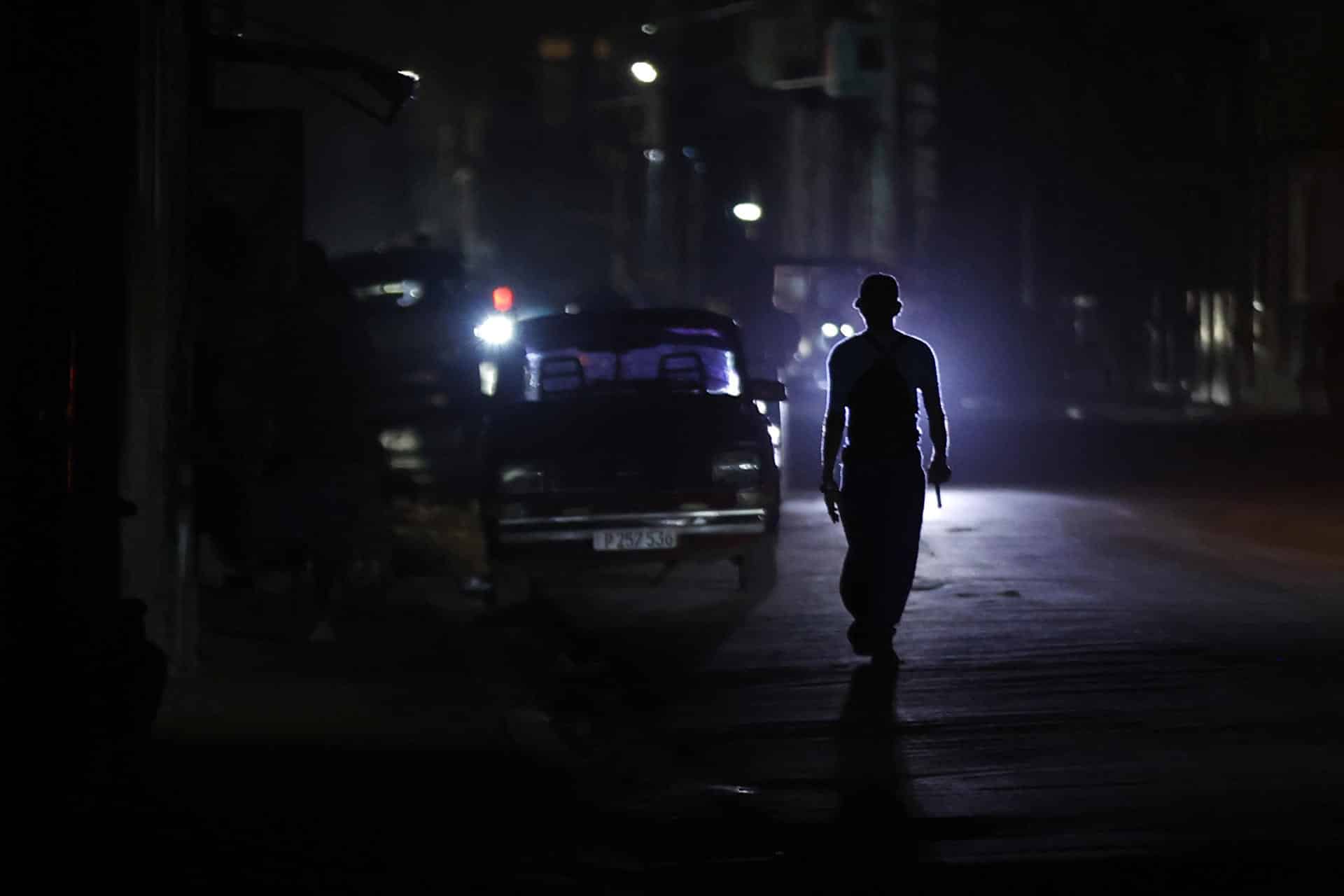 Fotografía del 9 de diciembre de 2025 que muestra a una persona que camina por una calle sin luz durante un apagón en La Habana (Cuba). EFE/ Ernesto Mastrascusa