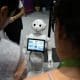 Unos visitantes hablan con el robot 'Pepper' en una imagen de archivo de una feria. EFE/EPA/SEBASTIEN NOGIER