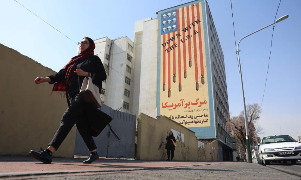 Una mujer pasa ante un mural contra EE.UU en un edificio de Teherán este 23 de febrero. EFE/EPA/ABEDIN TAHERKENAREH