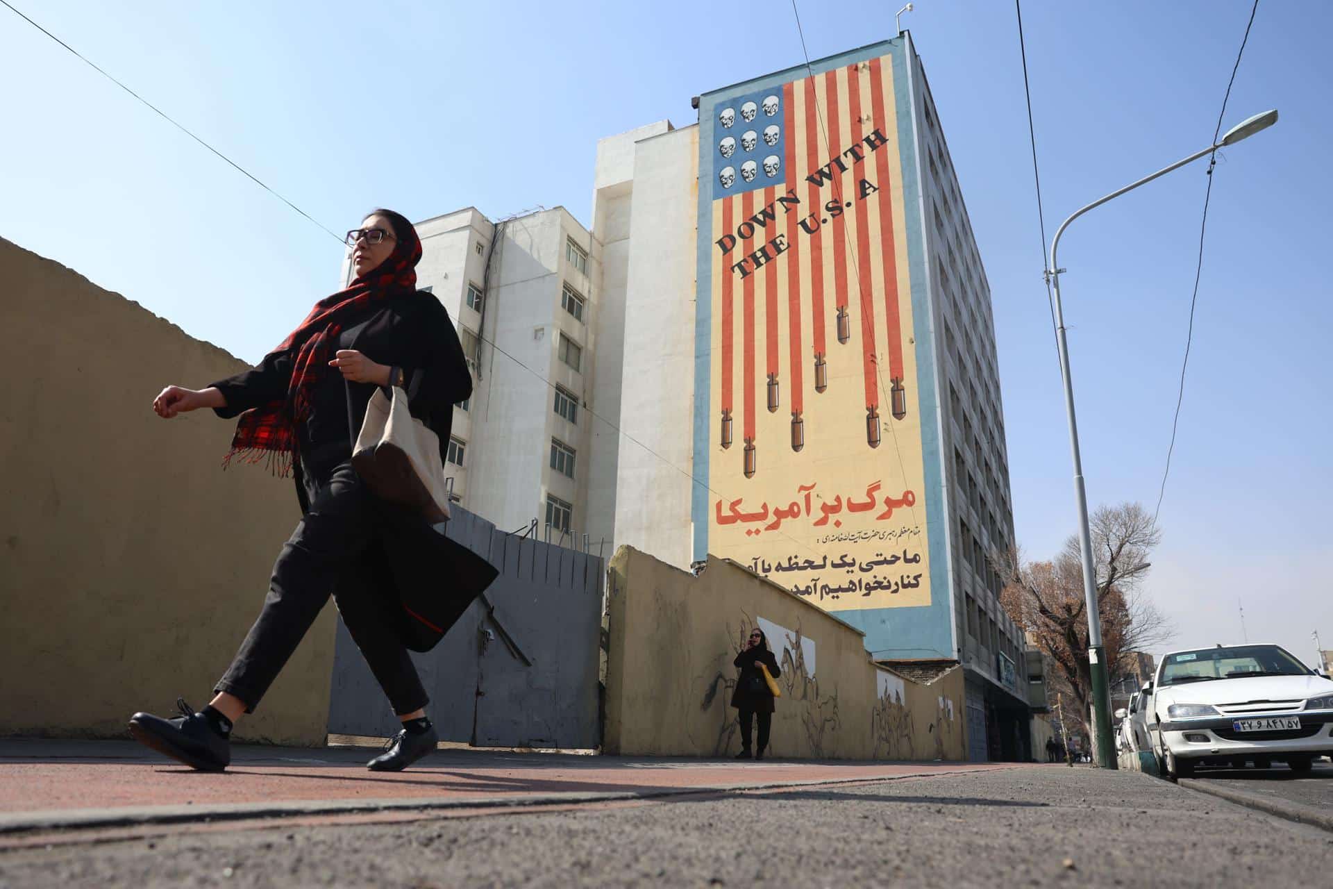Una mujer pasa ante un mural contra EE.UU en un edificio de Teherán este 23 de febrero. EFE/EPA/ABEDIN TAHERKENAREH