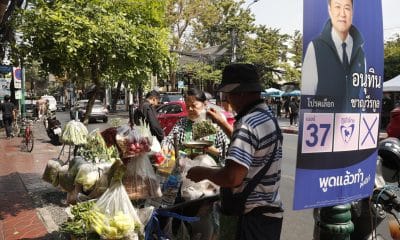 Bangkok (Tailandia), 04/02/2026.- Un vendedor ambulante vende verduras junto a un cartel de la campaña electoral del primer ministro tailandés y líder del partido conservador Bhumjaithai, Anutin Charnvirakul, en Bangkok. EFE/EPA/RUNGROJ YONGRIT