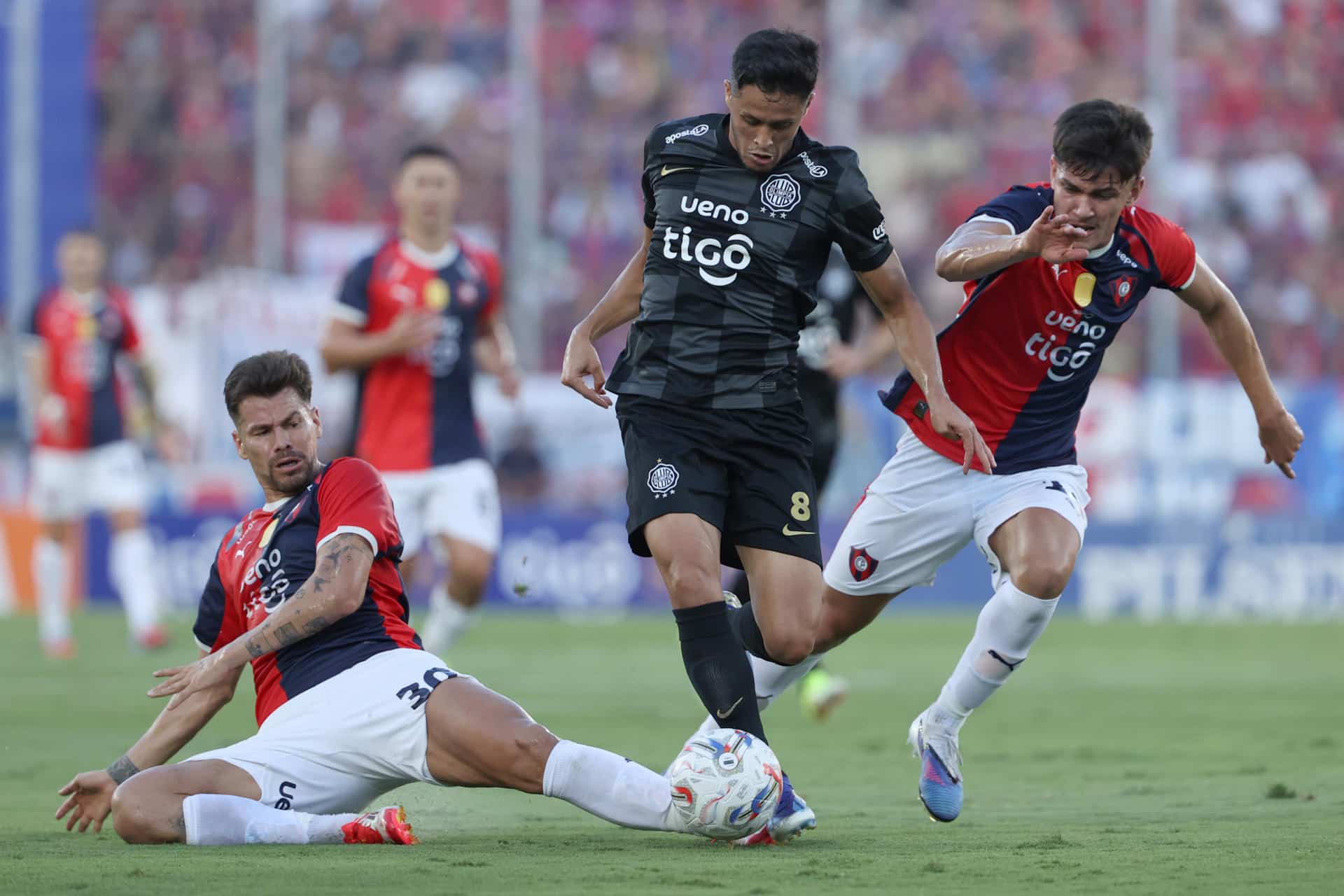 Gastón Giménez (i) y Lucas Quintana (d), de Cerro Porteño, disputan un balón con Alex Franco, de Olimpia, en un partido de la primera división de Paraguay entre Cerro Porteño y Olimpia en el estadio General Pablo Rojas en Asunción (Paraguay). EFE/Juan Pablo Pino