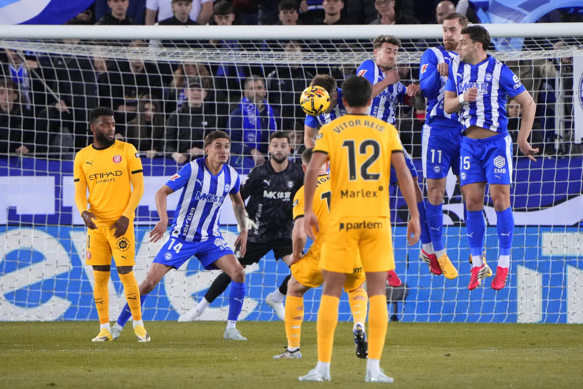 Los defensores del Alavés saltan ante una falta lanzada por el Girona durante el encuentro correspondiente a la jornada 25 de Laliga EA Sports que Alavés y Girona disputaron en el estadio de Mendizorroza, en Vitoria. EFE / ADRIAN RUIZ HIERRO.