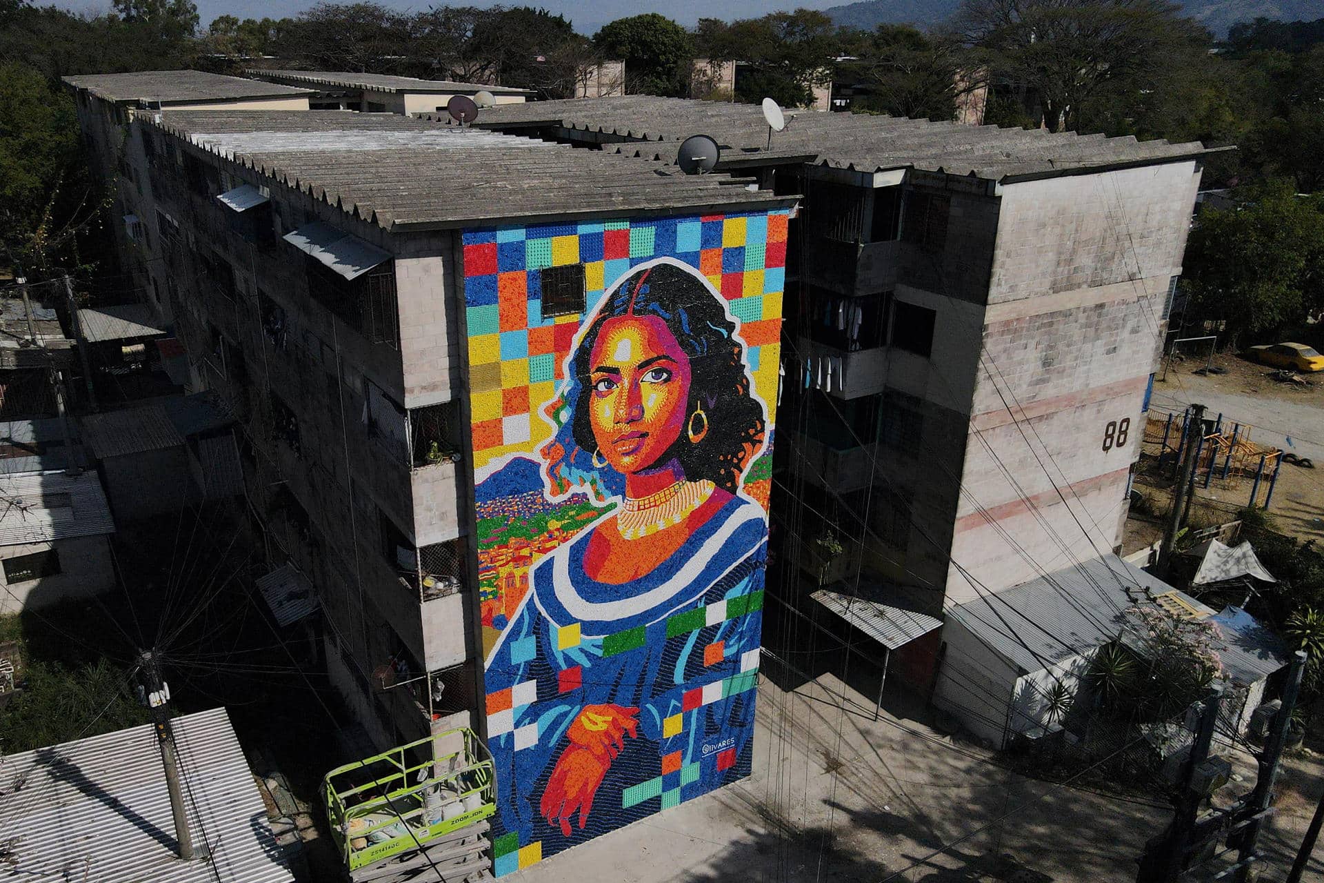 Fotografía aérea que muestra un mural elaborado con tapas plásticas este viernes, en un edificio multifamiliar en San Salvador (El Salvador). EFE/ Vladimir Chicas