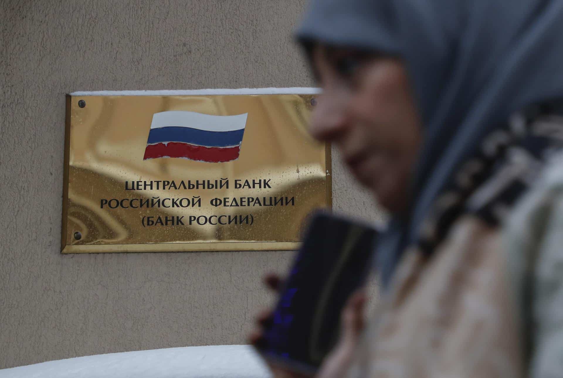 Una mujer camina frente a la sede del Banco Central de Rusia en Moscú. EFE/EPA/MAXIM SHIPENKOV