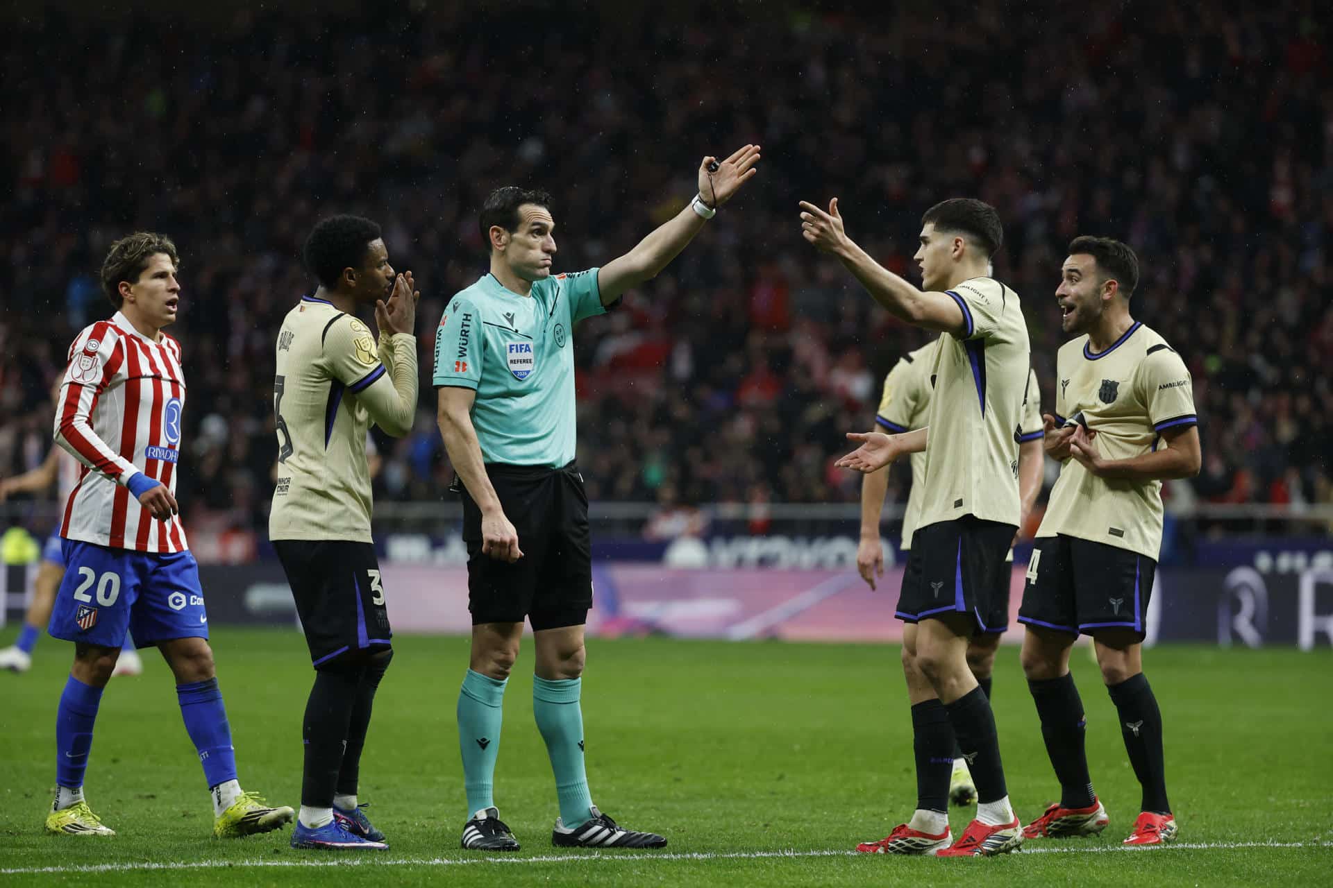 El árbitro Martínez Munuera señala una falta contra el Barcelona, durante el partido de ida de la semifinales de la Copa del Rey que Atlético de Madrid y FC Barcelona disputaron este jueves en el estadio Metropolitano, en Madrid. EFE/Juanjo Martín