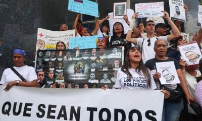 Personas sostienen carteles con imágenes de presos políticos este martes, durante la Asamblea Nacional sobre la Ley de Amnistía, en Caracas (Venezuela). EFE/ Miguel Gutiérrez