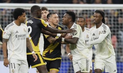 El delantero del Real Madrid Vinícius Jr (c) y los defensas del Rayo Vallecano Andrei Rațiu (3i) y Nobel Mendy (2i) durante el partido de LaLiga que enfrentó al Real Madrid y al Rayo Vallecano, este domingo, en el Santiago Bernabéu. EFE/ Ballesteros