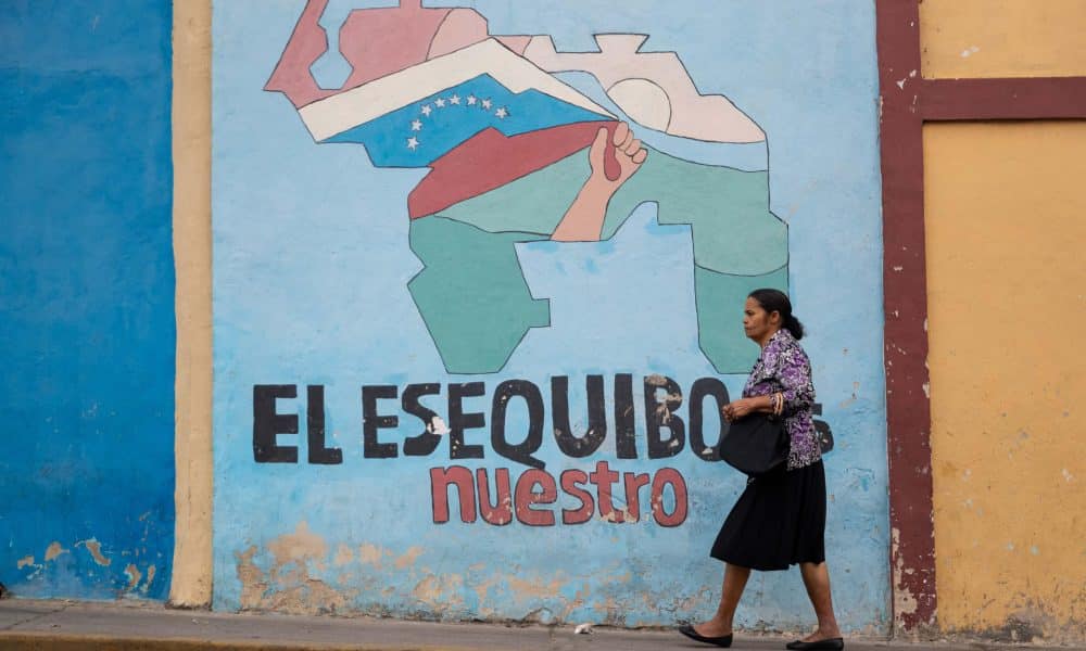 Fotografía de archivo que muestra a una persona caminando frente a un muro con un mensaje alegórico al territorio del Esequibo, en Caracas (Venezuela). EFE/ Ronald Peña