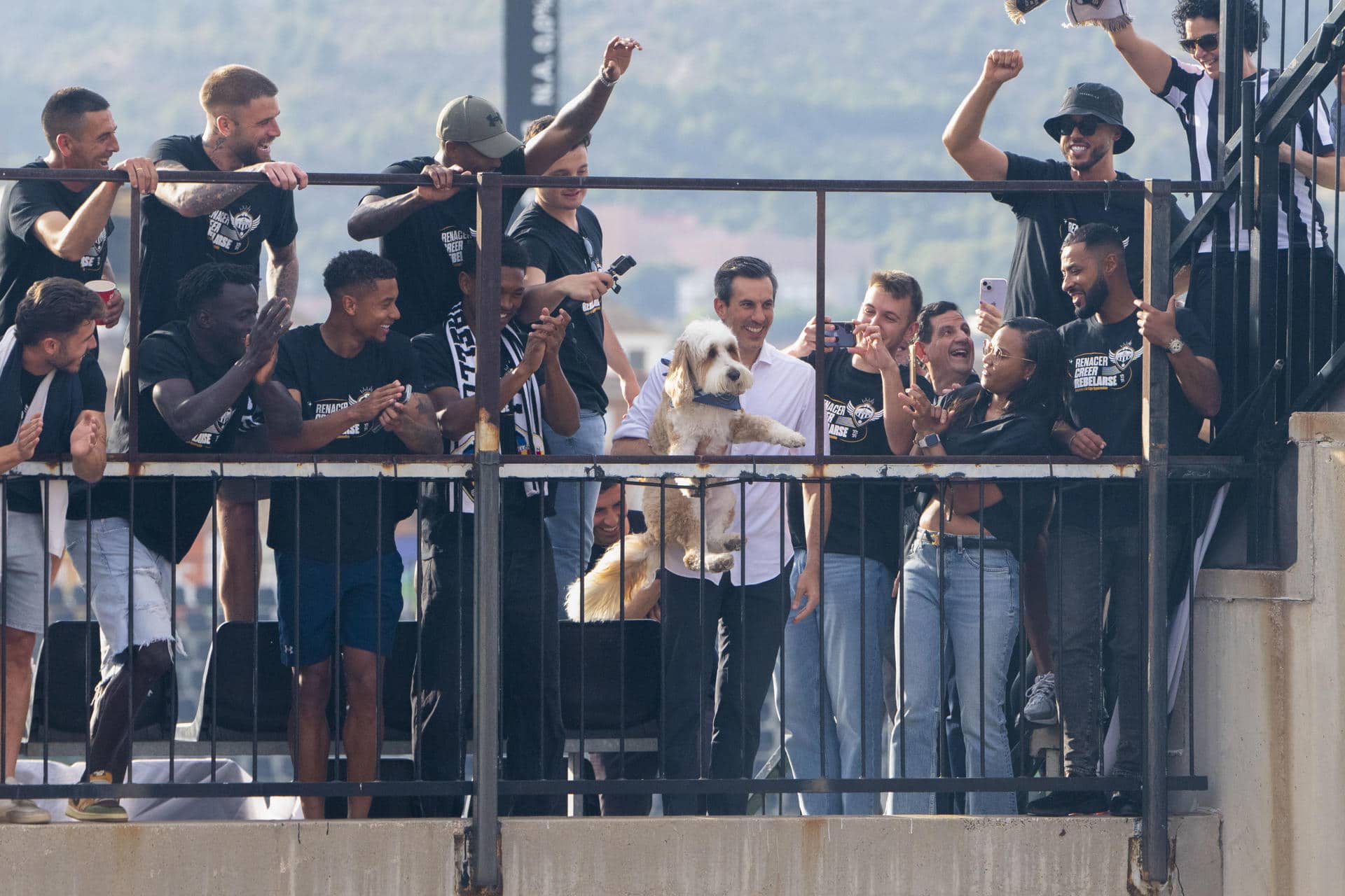 El presidente y propietario del CD Castellón, Haralabos Voulgaris,en el centro, sosteniendo a su perro, celebra con la afición el ascenso de conjunto a la segunda división del fútbol español. EFE/ Andreu Esteban