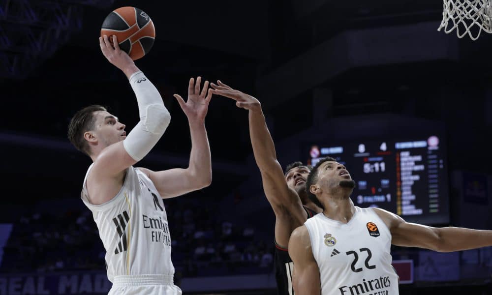 El alero croata del Real Madrid, Mario Hezonja (i), lanza a canasta durante el encuentro de Euroliga que disputan este jueves Real Madrid y Bayern Munich en el Movistar Arena de Madrid. EFE / Juanjo Martín.
