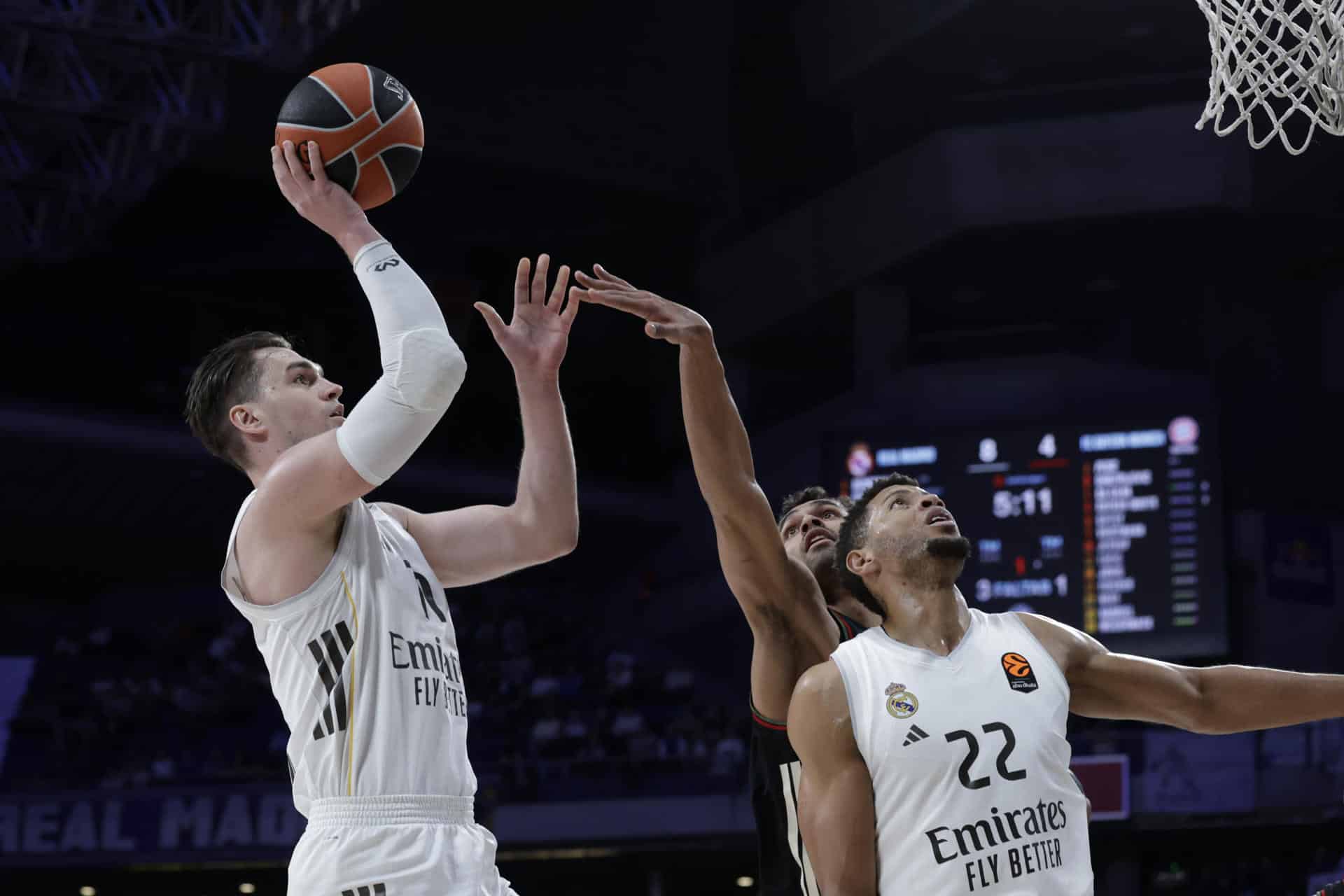 El alero croata del Real Madrid, Mario Hezonja (i), lanza a canasta durante el encuentro de Euroliga que disputan este jueves Real Madrid y Bayern Munich en el Movistar Arena de Madrid. EFE / Juanjo Martín.