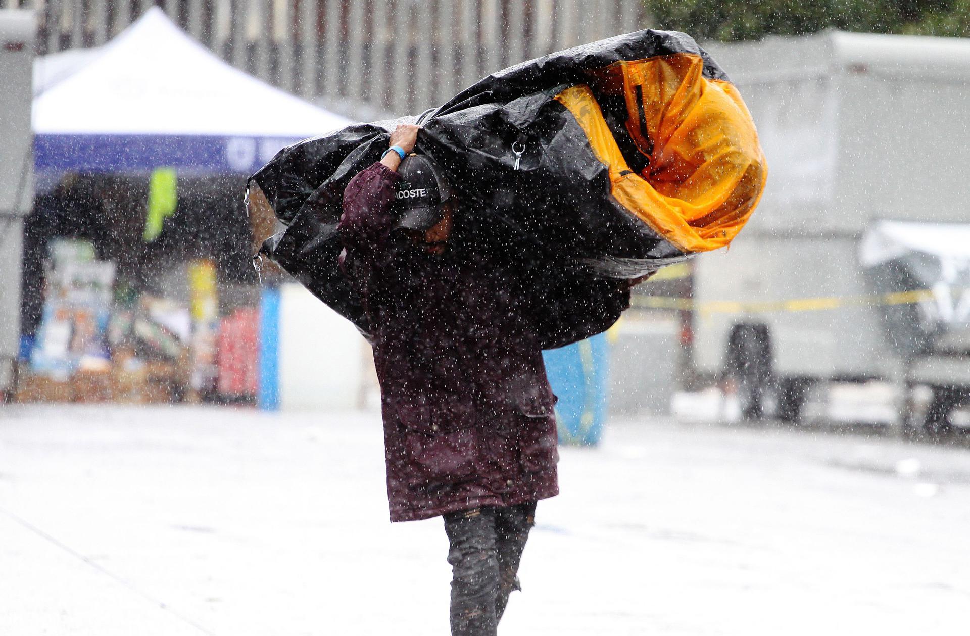 Fotografía de archivo de una persona que trata de protegerse de las fuertes lluvias en Tijuana (México). EFE/Alejandro Zepeda