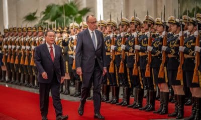 PEKÍN (China), 25/02/2026.- El canciller alemán, Friedrich Merz (centro), es recibido con honores militares por Li Qiang (izq.), primer ministro de China, en el Gran Salón del Pueblo de Pekín. EFE/EPA/Michael Kappeler / POOL