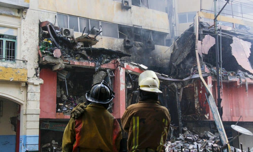 Integrantes del Cuerpo de Bomberos observan un edificio afectado por un incendio en Quito (Ecuador). EFE/ Gerardo Menoscal