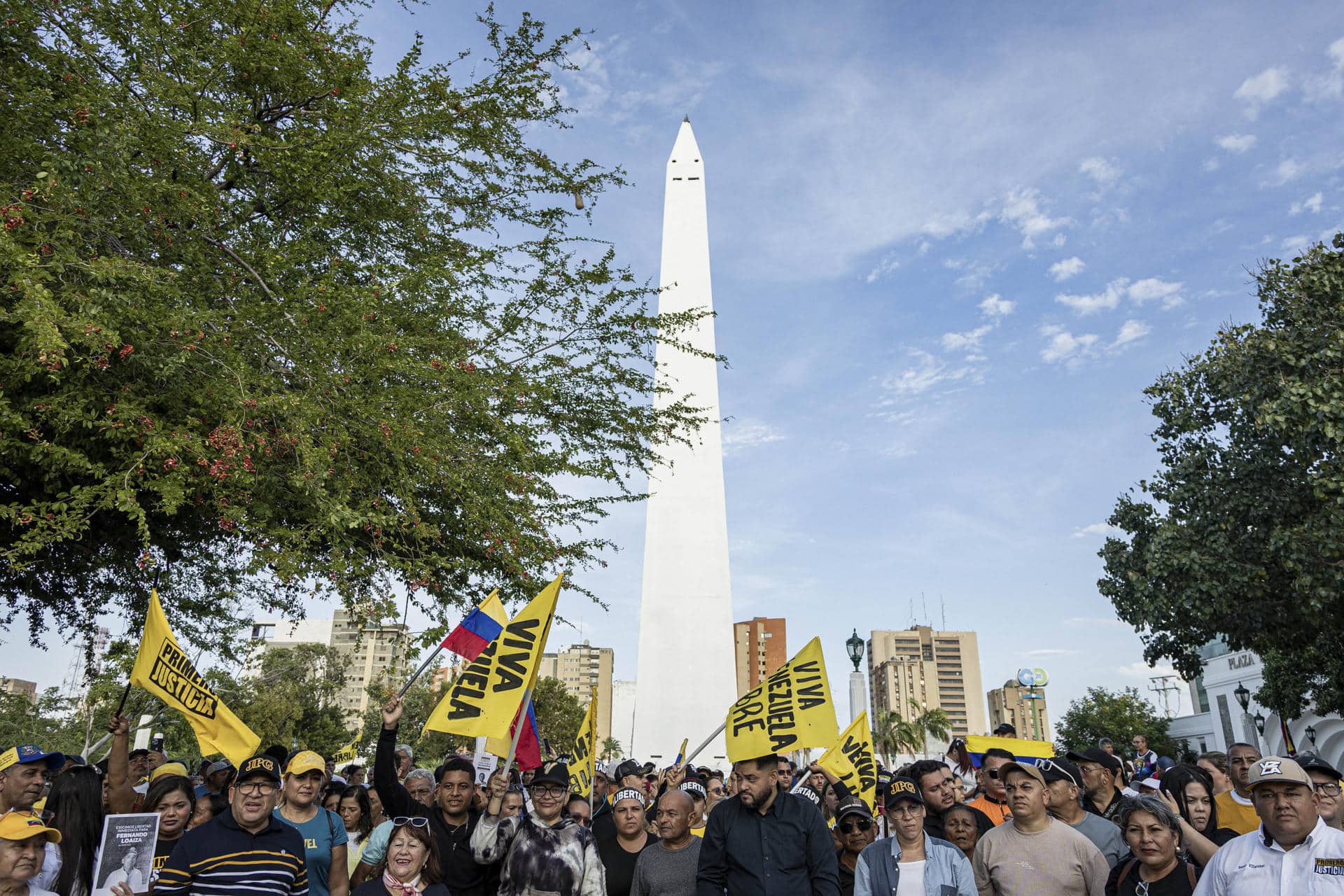 Personas sostienen banderas durante una manifestación por la libertad de los presos políticos y del opositor Juan Pablo Guanipa en Maracaibo (Venezuela). EFE/ Henry Chirinos