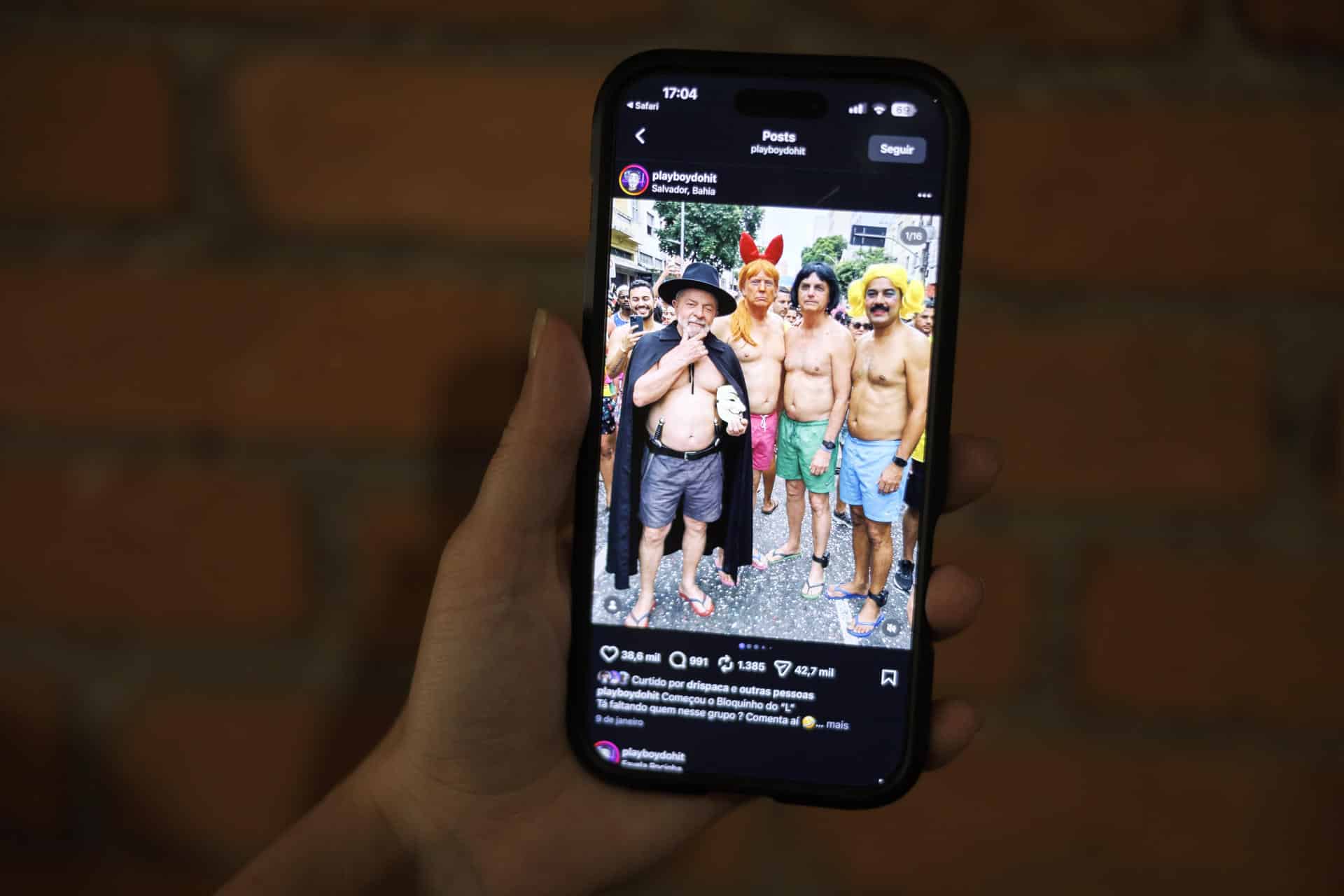 Una persona sostiene un teléfono que muestra una imagen generada por inteligencia artificial en la que reúne de izquierda a derecha al presidente de Brasil, Luiz Inácio Lula da Silva, el presidente de Estados Unidos, Donald Trump, el exmandatario Jair Bolsonaro, y el presidente de Venezuela, Nicolás Maduro, este domingo en São Paulo (Brasil). EFE/ Isaac Fontana