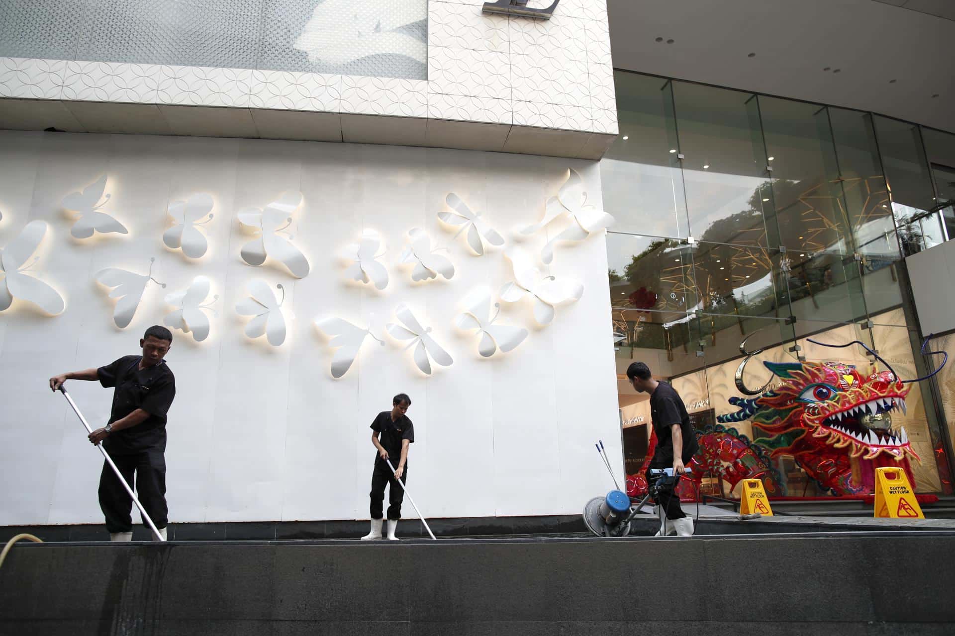 Bangkok (Thailand), 14/02/2026. Hombres limpian la entrada de un centro comercial en Bangkok, Tailandia. EFE/EPA/RUNGROJ YONGRIT