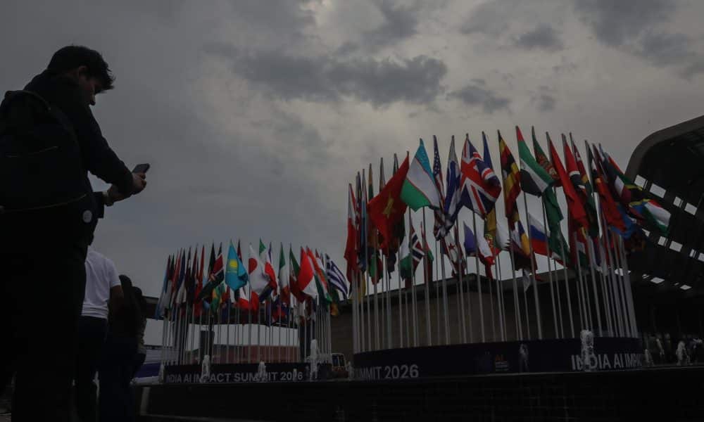 NUEVA DELHI (India), 18/02/2026.- Visitantes toman fotografías junto a las banderas de los países participantes en la Cumbre de Impacto de la IA 2026, celebrada en Bharat Mandapam, Nueva Delhi. EFE/EPA/RAJAT GUPTA