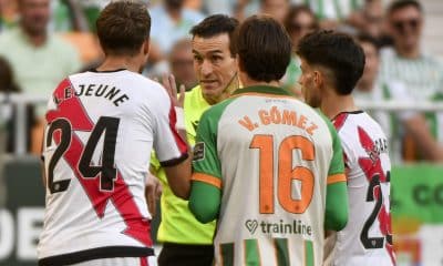 El árbitro del partido Juan Martínez Munuera (2i) habla con jugadores este sábado, durante el partido de la jornada 25 de LaLiga EA Sports que disputaron el Real Betis y el Rayo Vallecano este sábado en el estadio de La Cartuja de Sevilla. EFE/ Raúl Caro