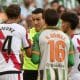 El árbitro del partido Juan Martínez Munuera (2i) habla con jugadores este sábado, durante el partido de la jornada 25 de LaLiga EA Sports que disputaron el Real Betis y el Rayo Vallecano este sábado en el estadio de La Cartuja de Sevilla. EFE/ Raúl Caro